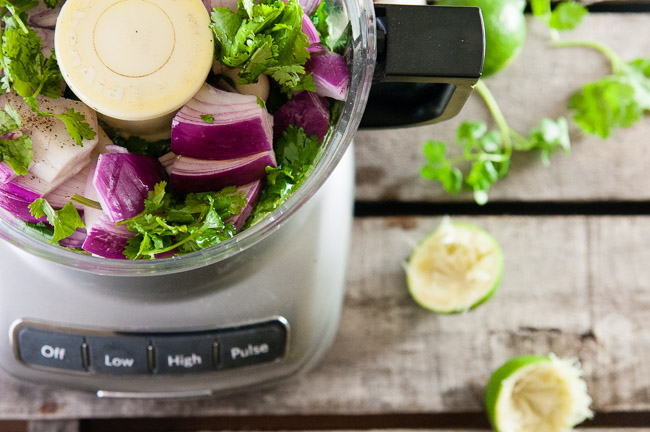 Herbs, red onion, garlic and lime in a food processor