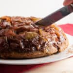 Oven Baked Apple Pancakes being cut with a knife to serve.