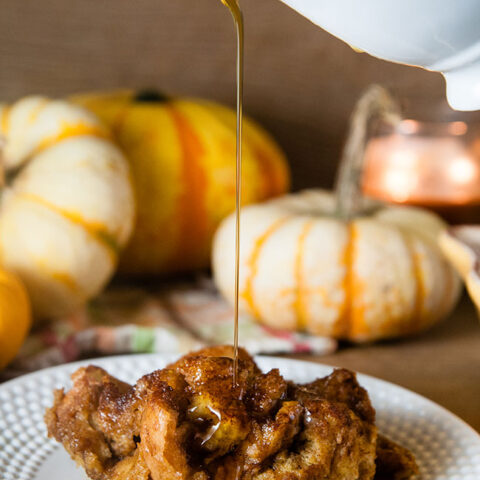 A piece of pumpkin French Toast casserole with maple syrup being drizzled on top