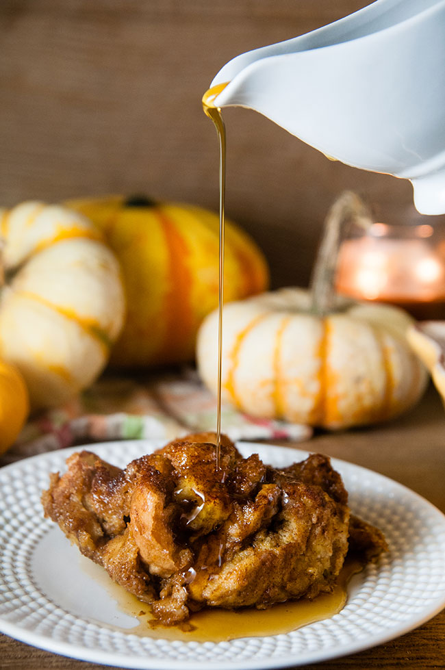 A piece of pumpkin French Toast casserole with maple syrup being drizzled on top