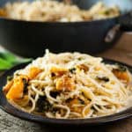 Spaghetti, kale, mushrooms, squash, garlic, sage, and walnuts on wood