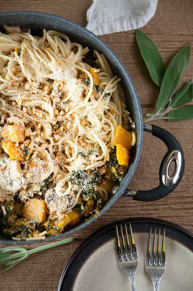 Spaghetti, kale, mushrooms, squash, garlic, sage, and walnuts on wood