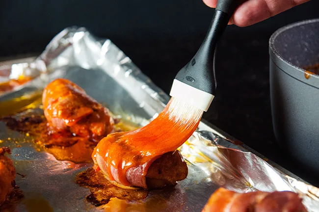 Homemade hot sauce being brushed onto wings