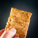 Triple Chocolate Chip Cookie Bars in a hand on a black background