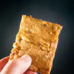 Triple Chocolate Chip Cookie Bars in a hand on a black background