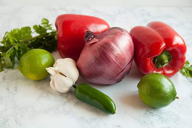 bell pepper, jalapeno, lime, garlic and cilantro on marble