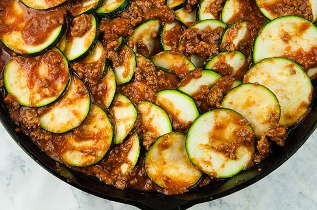 Zucchini slices in sauce in a skillet