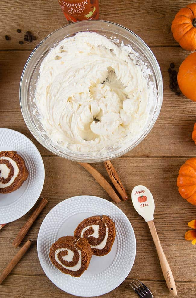 Boozy Pumpkin Spice Buttercream on wood with pumpkin roll slices