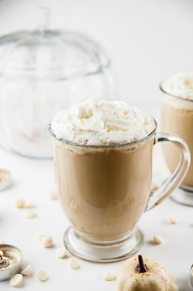 Cinderella Latte - a white chocolate pumpkin latte on white with a glass pumpkin and white pumpkins