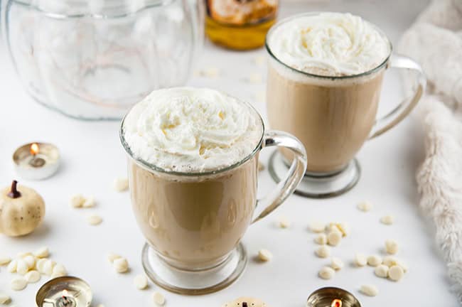 Cinderella Latte - a white chocolate pumpkin latte on white with a glass pumpkin and white pumpkins