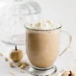 Cinderella Latte - a white chocolate pumpkin latte on white with a glass pumpkin and white pumpkins
