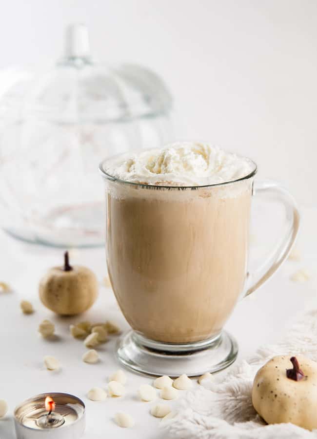 Cinderella Latte - a white chocolate pumpkin latte on white with a glass pumpkin and white pumpkins