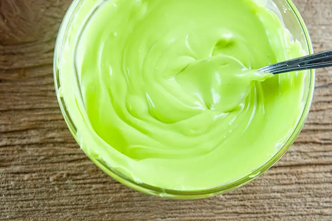 Melted green candy in a bowl on wood