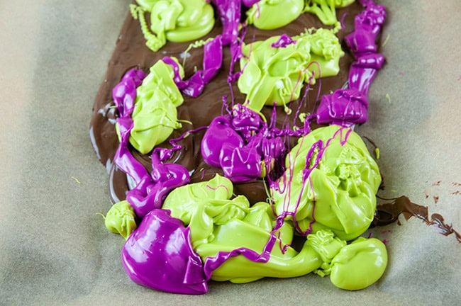 The melted candy on top of the melted chocolate on parchment paper