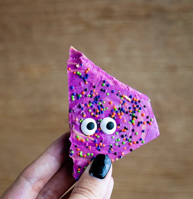 Halloween Monster Bark in a hand with black fingernails on a wood background