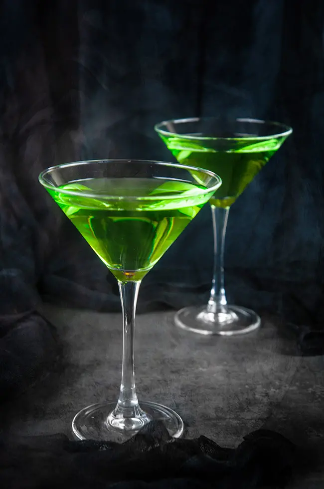 green poison apple cocktails martinis on black with smoke 