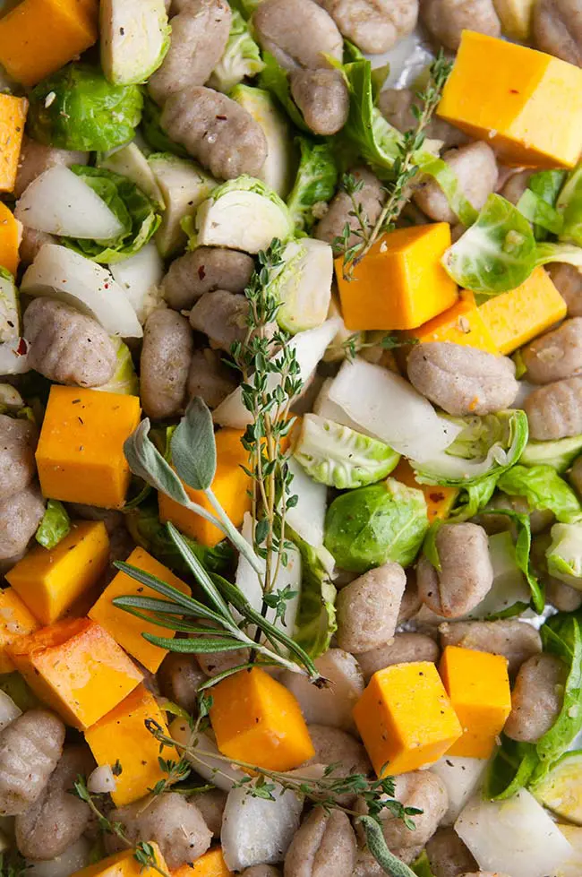 Butternut squash, Brussels sprouts, onions, herbs, and gnocchi on sheet pan