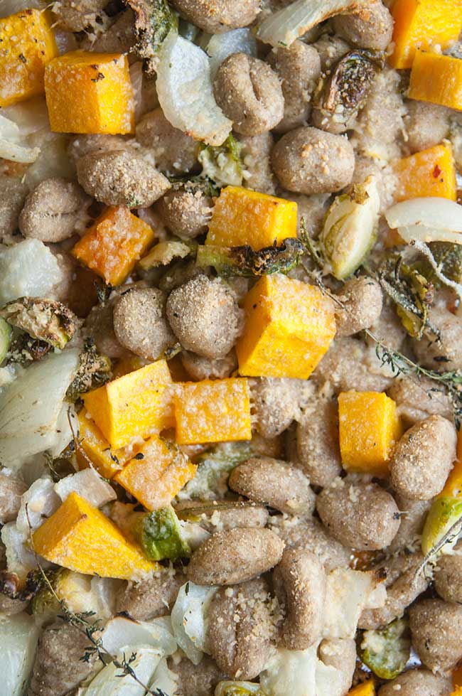 Cooked Butternut squash, Brussels sprouts, onions, herbs, and gnocchi on sheet pan