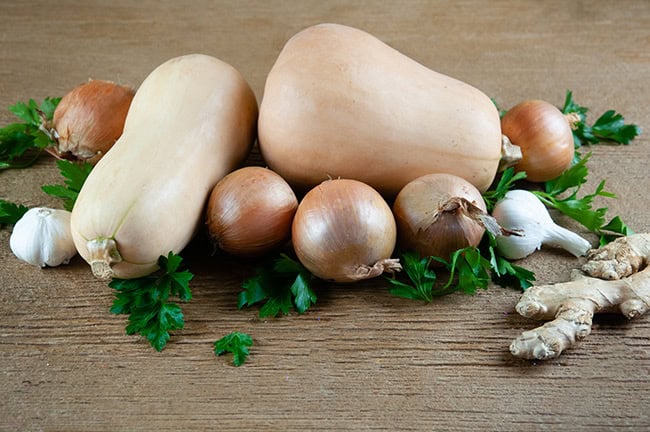 Butternut squahs, onions, garlic and ginger on wood