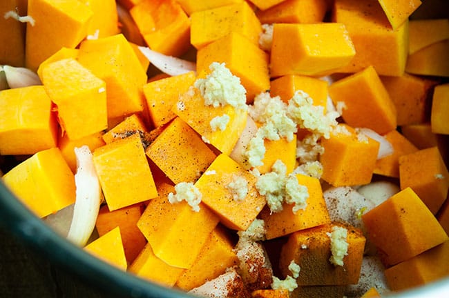 Cubed squash, rough chopped onions, garlic, and seasoning in the inner liner of the Instant Pot