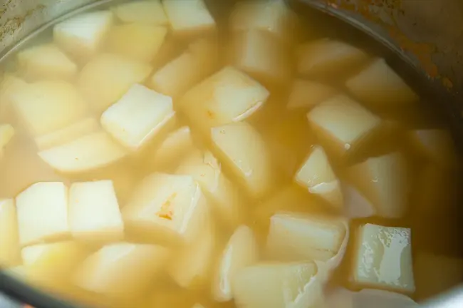 Cooked potato cubes in vegetable stock in an Instant Pot liner