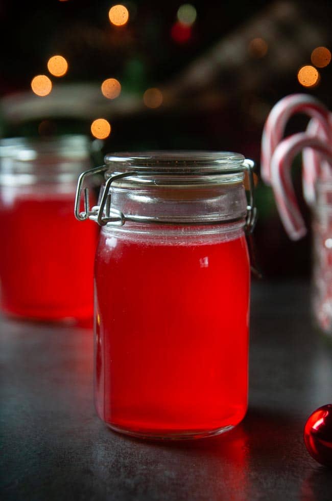 Candy Cane Vodka in jars in front of Christmas tree