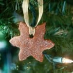 Easy cinnamon ornament shaped like a snowflake hanging on a Christmas tree