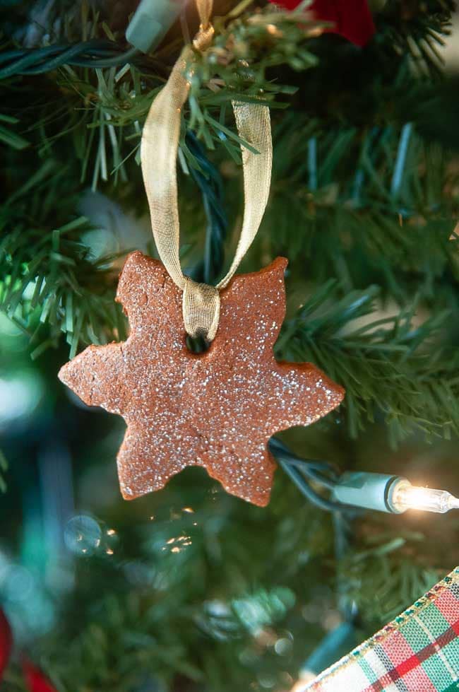 Easy cinnamon ornament shaped like a snowflake hanging on a Christmas tree