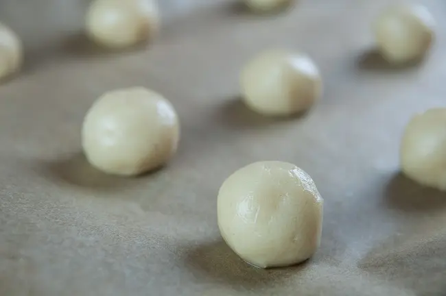 sugar cookie dough balls on parchment paper