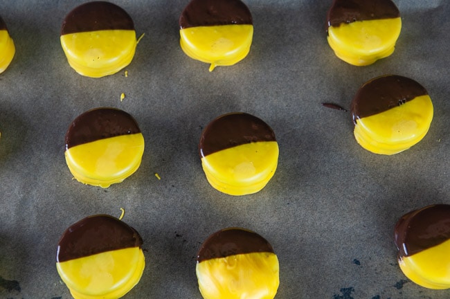 Oreos dipped in yellow melted candy and melted chocolate