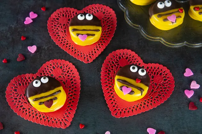 Bumblebee cookies perfect for Valentine's Day on red heart doilies on black