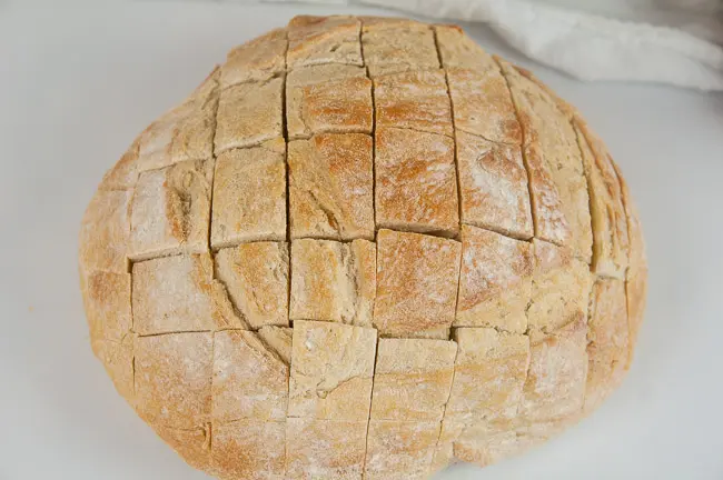 A boule of bread with a grid cut into it to make pull apart bread