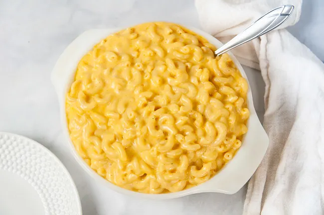 A white bowl full of creamy macaroni and cheese that was made in the pressure cooker.