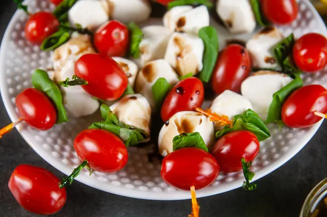 Mini caprese skewers drizzled with a balsamic reduction are an elegant start to any occasion