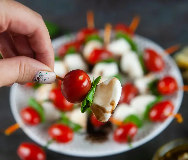 Mini caprese skewers drizzled with a balsamic reduction are an elegant start to any occasion