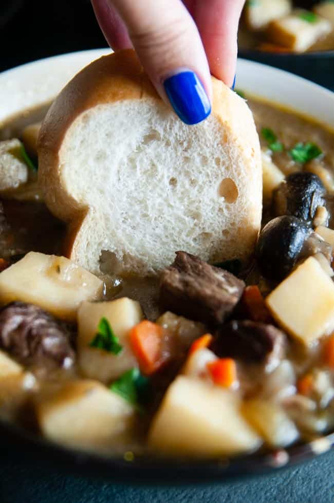 Bread being dipped into Dutch Oven Beef Stew