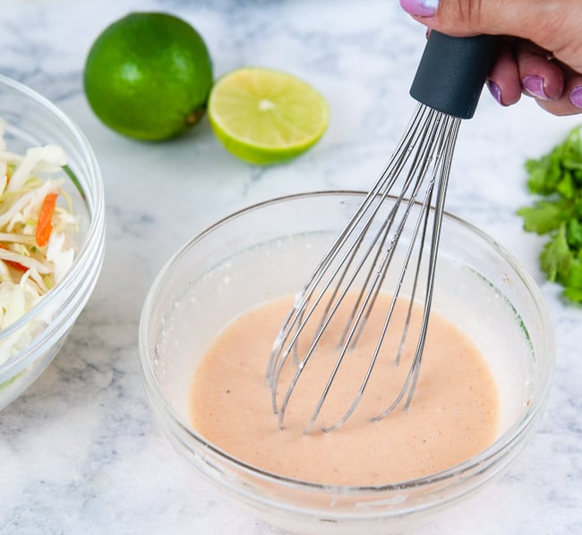whisking together the sweet and spicy dressing