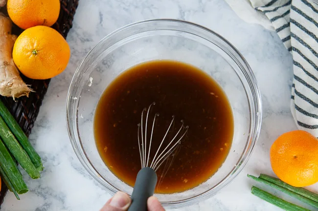 A bowl with marinade in it being whisked