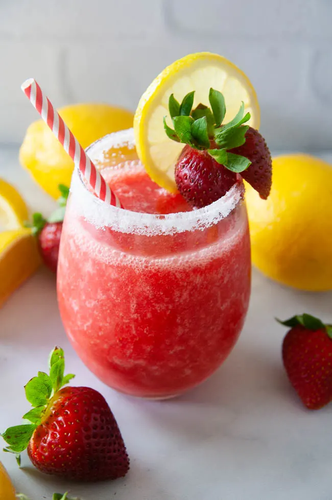 Boozy strawberry lemonade slushies make a fun drink for summer.
