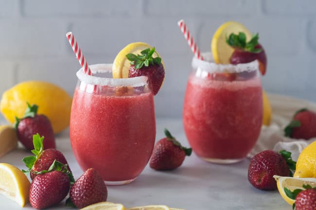 Boozy strawberry lemonade slushies make a fun drink for summer.