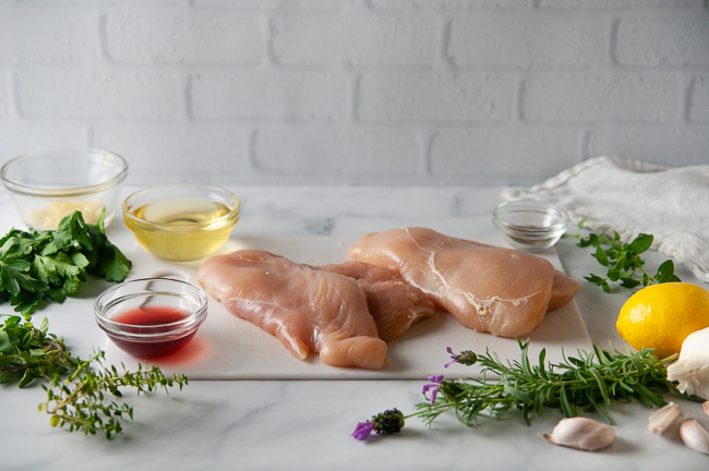 Ingredients for Greek chicken: chicken breasts, olive oil, red wine vinegar, herbs, garlic and lemon