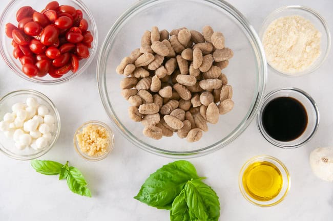 Ingredients for Air Fryer Gnocchi Caprese: Gnocchi, Cherry Tomatoes, Mozzarella, Garlic, Balsamic Vinegar, Olive Oil, Parmesan Cheese, Fresh Basil