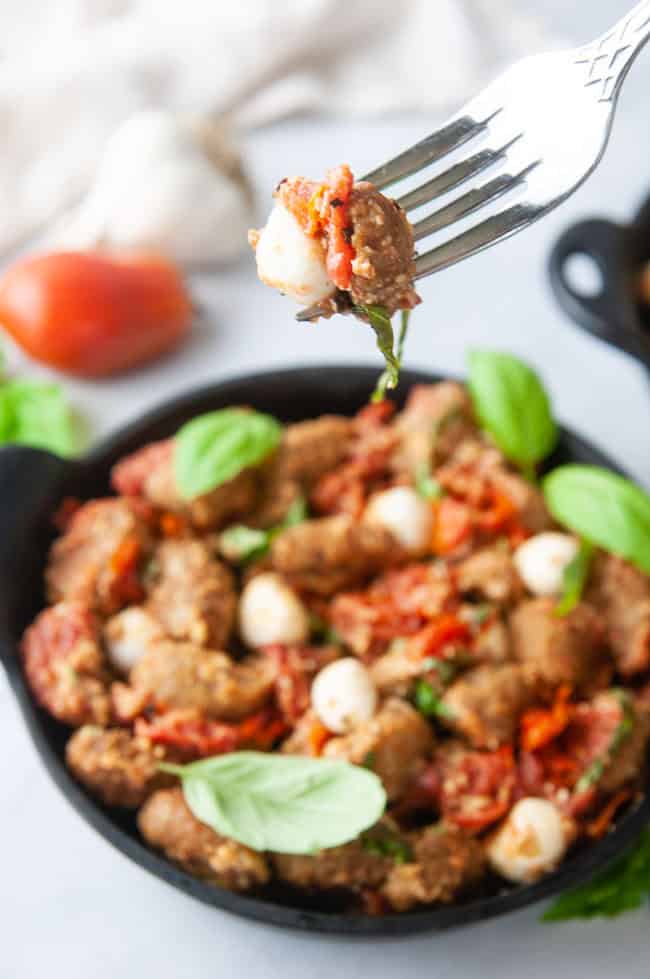 A perfect forkful of air fryer gnocchi with tomatoes, mozzarella and basil.