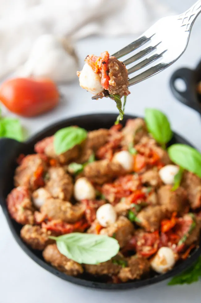 A perfect forkful of air fryer gnocchi with tomatoes, mozzarella and basil.