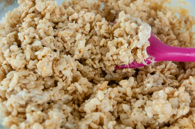 Stir the cereal mixture to combine it with the melted marshmallows.