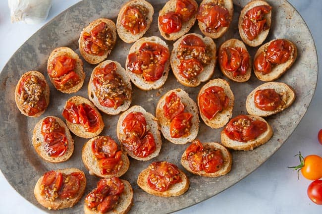 Spoon the roasted tomatoes on the toast to make the roasted tomato bruschetta.