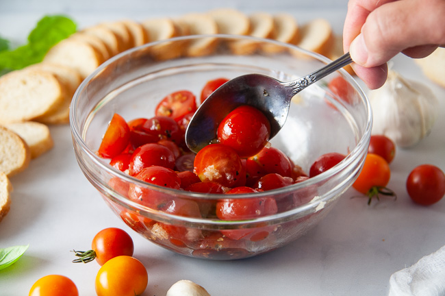 Toss the halved tomatoes with olive oil, balsamic vinegar, garlic, and salt and pepper.