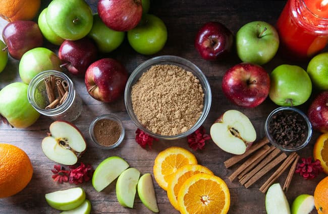 Ingredients for Homemade Apple Cider: Apples, Orange, Cinnamon, Cloves, Brown Sugar, Nutmeg, and Water