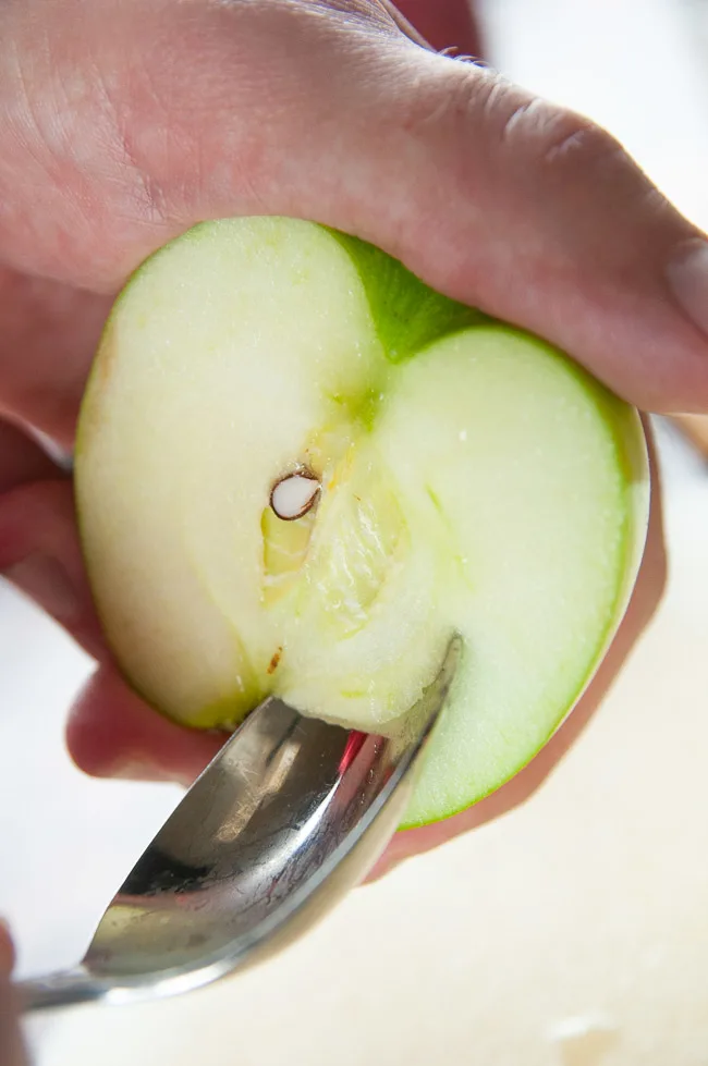 Scoop the core of the apple with a spoon.