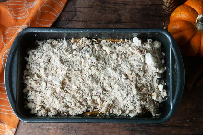 Top the loaf pan full of unbaked pumpkin bread with the streusel topping.